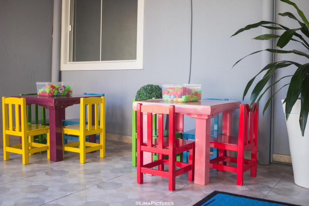 Espaço kids com mesinhas e cadeiras coloridas